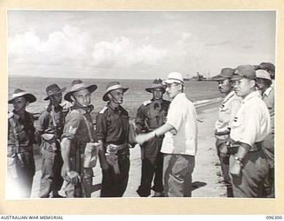 KAHILI, SOUTH BOUGAINVILLE. 1945-09-09. MAJOR F.C. TAYLOR, BUIN LIAISON GROUP, 2 CORPS AND MEMBERS OF HIS PARTY ASSEMBLING ON THE BEACH AFTER MEETING THE JAPANESE