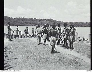 SEGI AREA, NEW GEORGIA, BRITISH SOLOMON ISLANDS PROTECTORATE. C.1943. A JAPANESE PRISONER OF WAR IS LED TO A BOAT TO BE TRANSFERRED TO AN AIRCRAFT (NOT SHOWN) FOR PASSAGE TO LUNGA. (NAVAL ..