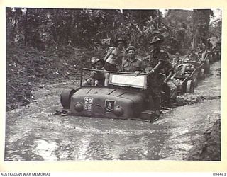 SOUTH BOUGAINVILLE. 1945-07-29. A JAPANESE PRIME MOVER BEING USED BY 29 INFANTRY BRIGADE, WALLOWING THROUGH ONE OF THE MANY MUD HOLES IN THE BUIN ROAD, WEST OF THE OGORATA RIVER. TRACKED VEHICLES ..