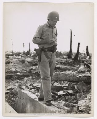 Photograph of Commander Harold G. Belford Surveying the Wreckage of a Japanese Pillbox