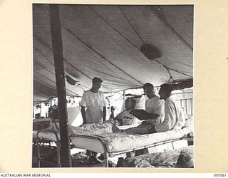CAPE WOM, WEWAK AREA, NEW GUINEA. 1945-08-28. PRIVATE F. CAUSBY, MEDICAL ORDERLY, IN WARD 4, 104 CASUALTY CLEARING STATION ADMINISTERING A DOSE OF MEDICINE TO GUNNER F. ROSS. PRIVATE G. EDWARDS ON ..