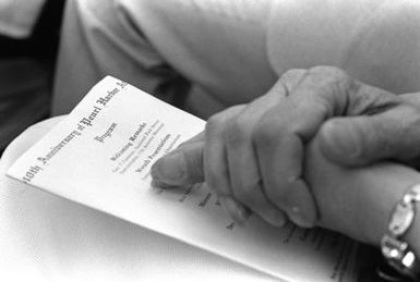 A guest's folded hands rest on the program for the ceremony aboard the USS ARIZONA Memorial commemorating the 40th anniversary of the Japanese attack on Pearl Harbor