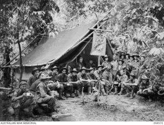 MUBO-SALAMAUA AREA, NEW GUINEA, 1943-07-21. TROOPS OF THE 2/6TH AUSTRALIAN INFANTRY BATTALION, ENJOY A REST AND A CUP OF TEA AT THE SALVATION ARMY HUT AT MAT-MAT. SHOWN ARE:- VX3486 PRIVATE A. ..