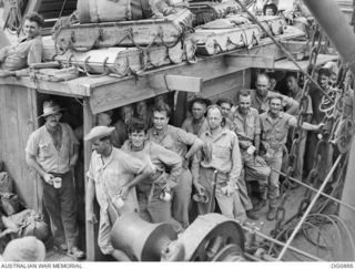 AT SEA BETWEEN GOODENOUGH ISLAND AND THE TROBRIAND ISLANDS, PAPUA. 1943-11-27. AIRMEN OF NO. 30 (BEAUFIGHTER) SQUADRON RAAF LINING UP FOR A MORNING CUP OF COFFEE ON BOARD THE SS HANYANG DURING THE ..