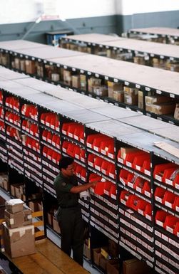 STAFF SGT. Jourdan Ornorg checks bins at the main supply warehouse of the forward supply section of the 619th MIlitary Airlift Support Squadron. The squadron is assigned with the task of finding whatever part may be needed to fill any of the 300 Military Airlift Command strategic airlift planes passing through the based each month