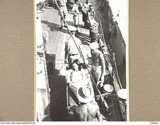 PORT MORESBY, PAPUA. 1942-09. AN AUSTRALIAN SOLDIER, WOUNDED IN THE FIGHTING IN NEW GUINEA, BEING CARRIED ON TO THE CORVETTE H.M.A.S. BENDIGO FOR FERRYING OUT TO THE HOSPITAL SHIP MANUNDA, LYING ..