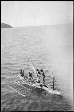 Outrigger canoe with a tall mast and person at bow, Port Moresby, Papua, ca. 1923 / Sarah Chinnery