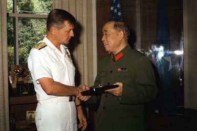 Mr. Xu Yimin, right, Defense and Military Attache, People's Republic of China, accepts a plaque from VADM Edward S. Briggs, deputy and chief of staff, while visiting his office at headquarters U.S. Pacific Fleet