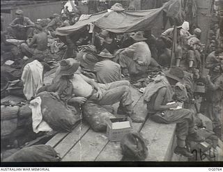 AT SEA IN THE ADMIRALTY ISLANDS AREA. 1944-03-08. RAAF AIRMEN AND AMERICAN TROOPS RELAX ON THE DECK OF A SHIP TAKING THEM TO THE ADMIRALTY ISLANDS