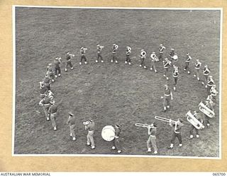 WONDECLA, QLD. 1944-04-05. THE BAND OF THE 2/2ND INFANTRY BATTALION PERFORMING THE MAZE AT THE FOOT OF THE JUDGES TOWER AT THE HERBERTON RACECOURSE