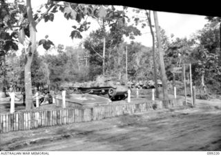 RABAUL, NEW BRITAIN, 1945-11-26. A JAPANESE TYPE 95 HA-GO LIGHT TANK STANDING BESIDE A MODEL OF THE COLOUR PATCH OF 2/4 ARMOURED REGIMENT, MOUNTED AT THE MAIN ENTRANCE TO THEIR CAMP