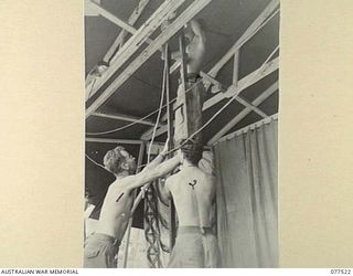 BOUGAINVILLE ISLAND. 1944-12-07. MEMBERS OF THE "TASMANIACS"- THE TASMANIA LINES OF COMMUNICATION CONCERT PARTY ADJUSTING THE STAGE CURTAINS IN PREPARATION FOR THE EVENING SHOW. IDENTIFIED ..
