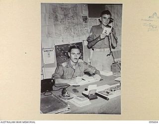 LAE AREA, NEW GUINEA. 1945-08-31. LIEUTENANT E.H. BALLARD (1) AND CORPORAL E.C. BRETT (2) AT WORK IN THE PUBLICATION SECTION, 9 LINES OF COMMUNICATION STATIONERY DEPOT