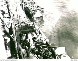 NEW BRITAIN, 1945-09. MEMBERS OF THE AUSTRALIAN MISSING PRISONERS INVESTIGATION UNIT (MPIU) READY FOR TRANSFER FROM SHIP TO SHORE AT SIMPSON HARBOUR, RABAUL. (RNZAF OFFICIAL PHOTOGRAPH.)