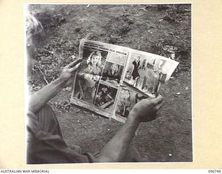 KARAWOP, NEW GUINEA, 1945-09-18. L-CPL V. COLLOTT, 2/6 CAVALRY COMMANDO REGIMENT, READING THE "PIX" MAGAZINE