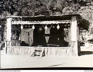 Rabaul, New Britain, 1945-10. A covered reviewing platform built of bamboo and roofed with matting stands on the parade ground of a former Japanese prisoner-of-war (POW) camp for captured ..