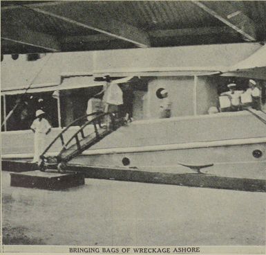 Sailors hauling bags of wreckage from the Samoan Clipper from the Avocet to the wharf