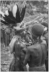 Bride price ritual: bride with feather and marsupial fur headdress, other women paint her face