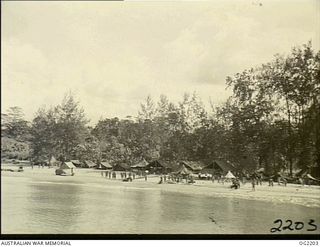 BOUGAINVILLE ISLAND, SOLOMON ISLANDS. C. 1945-01-25. ON THE BEACH GREEN-CLAD AUSTRALIAN MILITARY FORCES TROOPS EAGERLY AWAIT THE MAILBAGS AS THEY DROP FROM THE ANSON AIRCRAFT OF NO. 10 ..