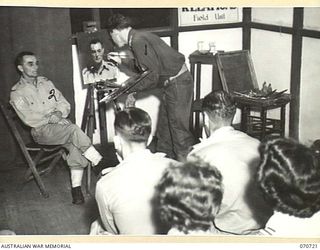 PORT MORESBY, PAPUA, NEW GUINEA, 1944-02-02. VX93433 CAPTAIN W.A. DARGIE (1), OFFICIAL WAR ARTIST, MILITARY HISTORY SECTION, LECTURING AND DEMONSTRATING PORTRAIT PAINTING USING QX27970 SERGEANT W. ..