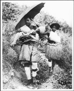 New Guinea, Mount Lamington volcano explosion, 1951 : a native and his injured son are shaded by his daughter with an umberella as they come from their village Higatoura. Their mother and wife lost her life in the blast, many thousands of natives died in the blast / Ern McQuillan