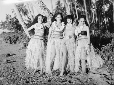 [Portrait of four Pacific Island women in grass skirts]