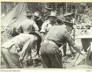 TOKO, BOUGAINVILLE, SOLOMON ISLANDS. 1945-03-26. TX2002 BRIGADIER J. FIELD, DSO, ED, COMMANDER, 7TH INFANTRY BRIGADE (6), AT HEADQUARTERS 7TH INFANTRY BRIGADE, INDICATES POSITIONS TO VX1 GENERAL ..