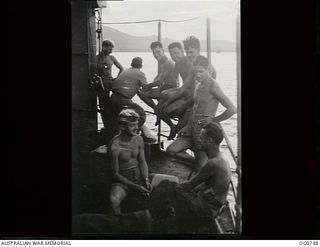 MILNE BAY, PAPUA. C.1944-02. AIRMEN OF NO. 75 SQUADRON RAAF RELAXING AT THE STERN OF THE SHIP AT SUNSET, BEFORE GOING TO LAE