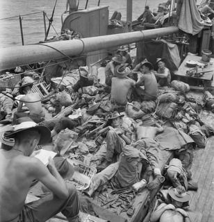 NEW BRITAIN. 1945-05-01. TROOPS OF A COMPANY, 37/52 INFANTRY BATTALION, RELAXING ABOARD THE AK82, A VESSEL ON STRENGTH OF THE 16 WATERCRAFT COMPANY, ROYAL AUSTRALIAN ENGINEERS, DURING MOVEMENT OFF ..