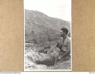 KESAWAI, NEW GUINEA. 1943-12-10. QX11545 PRIVATE R. MOBBS OF "C" COMPANY, 2/31ST AUSTRALIAN INFANTRY BATTALION, 25TH AUSTRALIAN INFANTRY BRIGADE, IN AN OBSERVATION POST OVERLOOKING THE EVAPIA RIVER ..