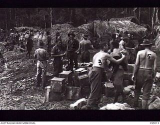 DUMPU, NEW GUINEA. 1943-10-16. NATIVE CARRIERS ARRIVING WITH SUPPLIES AT A FORWARD DETAILS ISSUING DEPOT, CONTROLLED BY NO. 7 PLATOON, "A" COMPANY, 2/27TH AUSTRALIAN SUPPLY DEPOT COMPANY AFTER THE ..