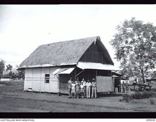 RABAUL, NEW BRITAIN, 1946-03-29. A CHINESE FAMILY OUTSIDE ONE OF THE NEWLY CONSTRUCTED HOMES IN THE NEW CHINATOWN SITUATED NEAR MATUPI CRATER. ALTHOUGH RAZED BY ALLIED BOMBING THE TOWN COMMENCED TO ..