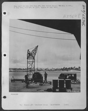 Mechanics Tune Up A Wright R-3350 Engine, Used By The B-29 At The Guam Air Depot, Where Marianas-Based Superfortresses Are Kept In Tiptop Shape For Their Long Runs To Tokyo. Airfield Where Planes Are Parked Is Shown In The Background. (U.S. Air Force Number D58121AC)