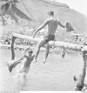 ZENAG, NEW GUINEA, 1944-02-27. NX65343 SAPPER R.D. AITKEN (1) AND VX36418 SAPPER L.G. BAKER (2), USING WASTE FILLED SANDBAGS DURING A SPORTS CARNIVAL HELD IN A CREEK DAMMED BY PERSONNEL OF THE ..