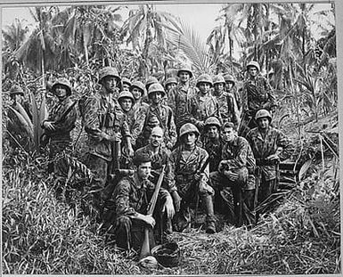 These men have earned the bloody reputation of being skillful jungle fighters. They are U.S. Marine Raiders gathered in front of a Japanese dugout on Cape Totkina on Bougainville, Solomon Islands, which thry helped to take.