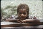 Young girl leans on house veranda