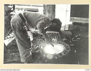 LABU, NEW GUINEA. 1944-10-03. CRAFTSMAN J. HARDMAN, A WELDER OF THE 1ST WATERCRAFT WORKSHOPS, WELDING A BAD CRACK IN ONE OF THE CYLINDER HEADS OF THE ENGINE OF THE "FRANCES PEAT". THE "FRANCES ..