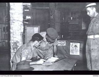 RABAUL, NEW BRITAIN, 1946-04-05. MAJOR-GENERAL B.M. MORRIS, GENERAL OFFICER COMMANDING 8 MILITARY DISTRICT, SPEAKING TO CORPORAL A.J. PAYNE, AT THE NEW AUSTRALIAN ARMY EDUCATION SERVICE CENTRE, HQ ..