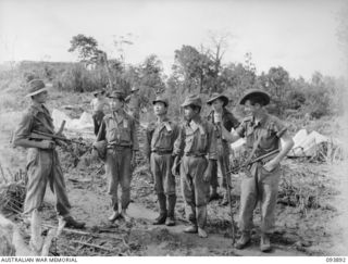 ULEBILUM RIDGE, YAMIL SECTOR, NEW GUINEA, 1945-07-08. PRIVATE J.H. PITCHER (1), AND CORPORAL R.R. WOOLLEY (2), MEMBERS OF 2/5 INFANTRY BATTALION, ESCORTING THREE JAPANESE SOLDIERS WHO HAD ..