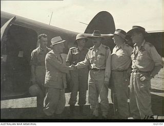 HOLLANDIA, DUTCH NEW GUINEA. C. 1944-06. THE MINISTER FOR WAR ORGANISATION OF INDUSTRY, JOHN DEDMAN, TOPEE IN HAND, AND THE MINISTER FOR AIR, ARTHUR DRAKEFORD, ON THEIR ARRIVAL AT A DUTCH NEW ..