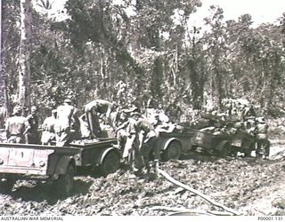 THE SOLOMON ISLANDS, 1945-04-24/27. AUSTRALIAN SERVICEMEN REMOVING WEIGHT FROM SOME OF THE TRAILERS IN THE PREVIOUS PHOTOGRAPH IN AN EFFORT TO GET THEM MOVING ON BOUGAINVILLE ISLAND. (RNZAF ..