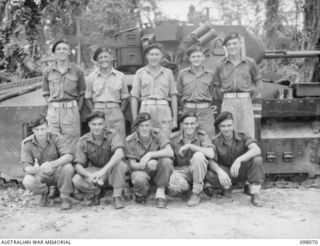 Group portrait of the personnel of No. 3 Troop, A Squadron, 2/4th Armoured Regiment. Left to right, back row: NX80405 Trooper (Tpr) G N H Heath of Mosman, NSW; NX80657 Tpr E C Herfort of Crows ..