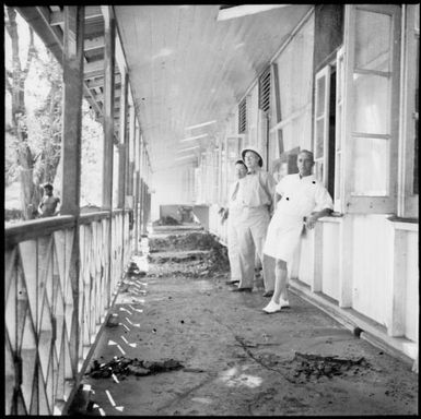 Men standing on a verandah amid piles of debris, Rabaul, New Guinea, 1937 / Sarah Chinnery