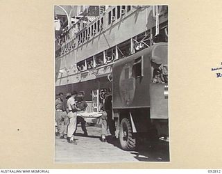 LAE, NEW GUINEA. 1945-06-09. PATIENTS OF 2/7 GENERAL HOSPITAL BEING UNLOADED FROM AMBULANCES AT MILFORD HAVEN WHARF FOR EMBARKATION ON TO THE HOSPITAL SHIP MANUNDA