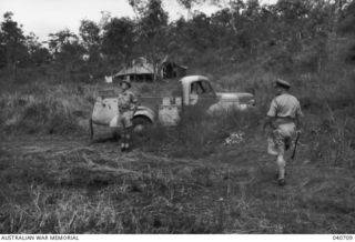 Major General A S Allen CB CBE DSO VD (right), Commanding 7th Australian Division, after reviewing a parade of the 21st Australian Infantry Brigade moves to a position, near his truck, to take the ..