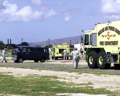 US Air Force Members of the Hickam Air Force Base, Hawaii, Fire Department respond to an accident site. The accident is part of the MAJOR ACCIDENT RESPONSE EXERCISE (MARE), simulating an aircraft accident and aircraft parts striking a POV (Privately Owned Vehicle). The crash rescue squad moves in to try to rescue trapped crash victims in the van, on Hickam AFB, on October 30th, 2000