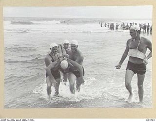 TOROKINA, BOUGAINVILLE, 1945-07-08. THE SOLOMON ISLAND SURF LIFE SAVING CLUB TEAM BRINGING IN A PATIENT DURING RESCUE DISPLAY AT THE CHAMPIONSHIP SURF CARNIVAL HELD BY SOLOMON ISLAND SURF LIFE ..