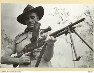 PAPUA. 1942-08-19. A DIGGER EXPLAINS HOW A CAPTURED JAPANESE MACHINE GUN IS OPERATED