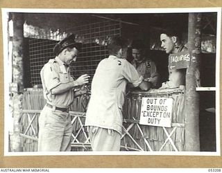 MILNE BAY, NEW GUINEA. 1943-06-26. MAKING ENQUIRIES AT THE CAMP COMMANDANT'S OFFICE, HEADQUARTERS, 5TH AUSTRALIAN DIVISION, FROM LEFT TO RIGHT:- Q46341 DRIVER G. A. COWLEY, Q71286 PRIVATE A. J. ..