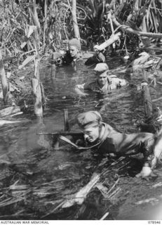 Members of a contact patrol from D Company, 42nd Infantry Battalion negotiating a deep section of the swamp during their patrol towards enemy territory. The soldier at the rear is Private John ..